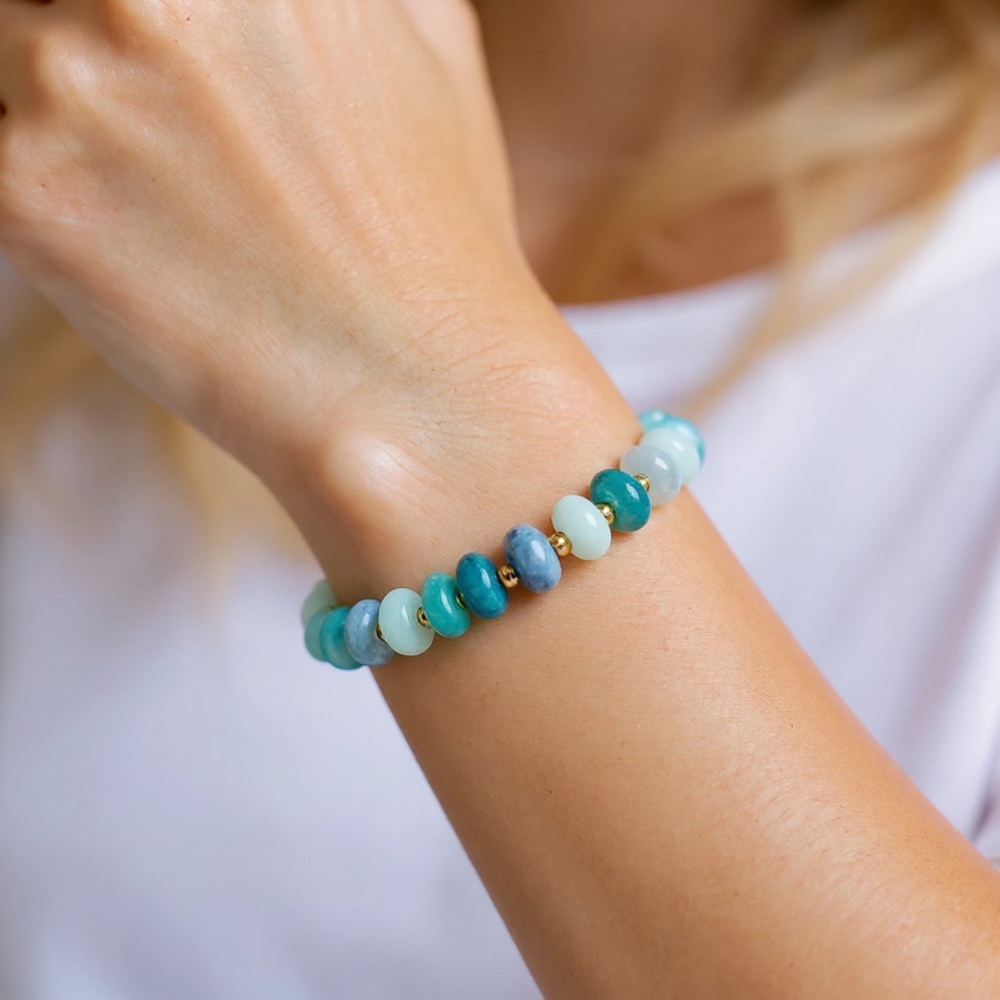 Blue quartz stretch bracelet with gold beads on model wrist 