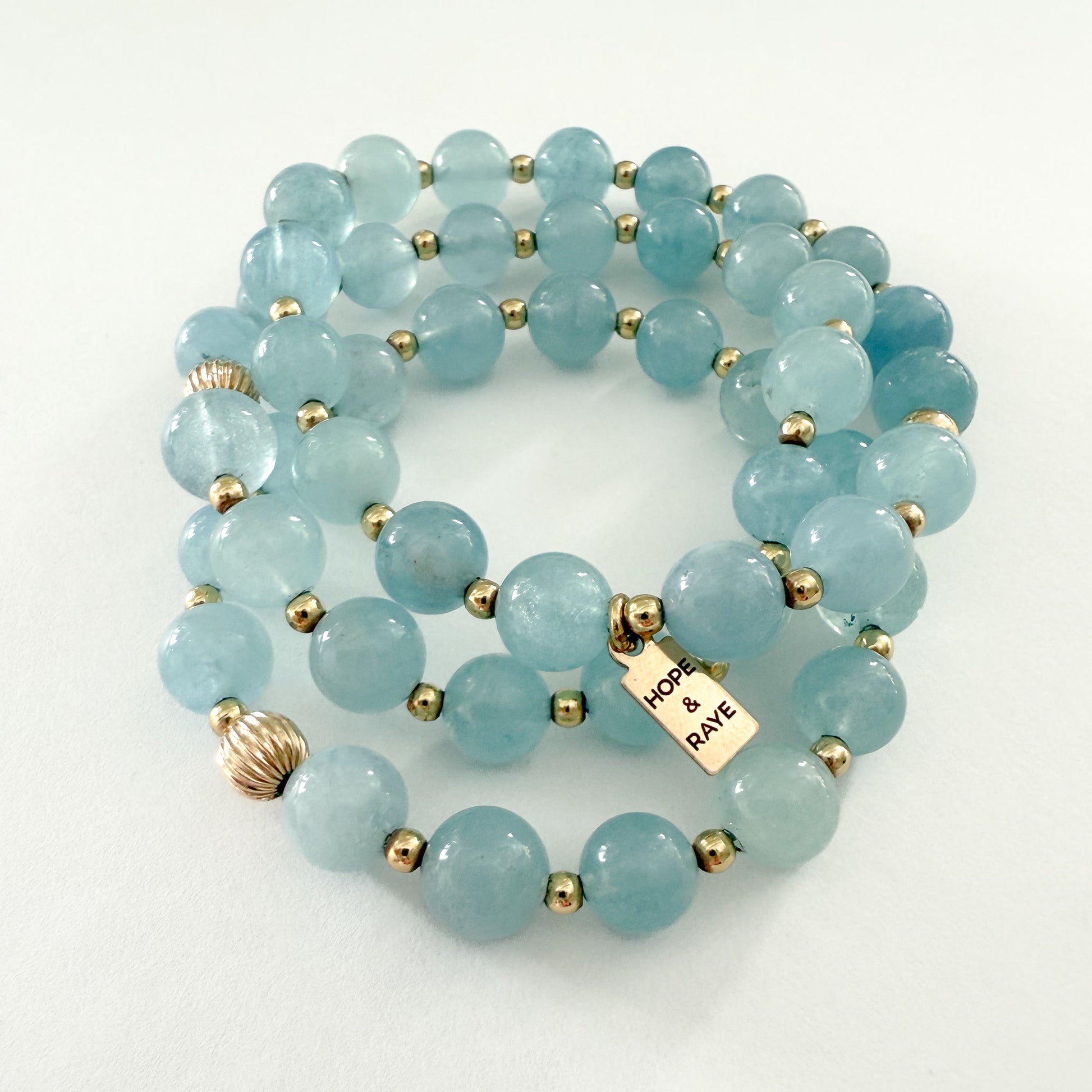 Natural aquamarine bracelet stack with 18K gold filled beads. Set of 3 stackable bracelets featuring genuine aquamarine gemstones and gold accents. Perfect for everyday luxury or holiday gifting. Handcrafted in Atlanta, Georgia by HOPE & RAYE. Each piece is designed to layer beautifully or wear solo. Shop this timeless blue and gold bracelet set.
