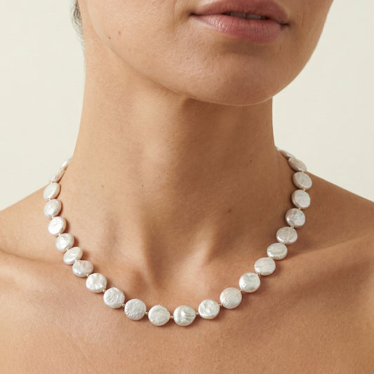 Natural freshwater coin, pearl necklace worn on models neck. Handcrafted by HOPE & RAYE.
