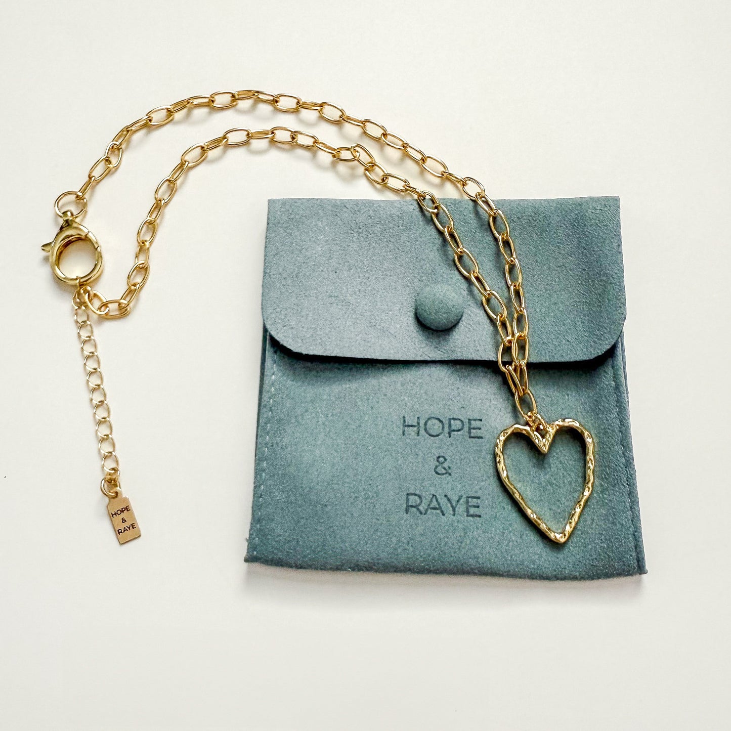 Gold hammered heart charm necklace by Hope and Raye. Ships gift ready in velvet pouch and box. 