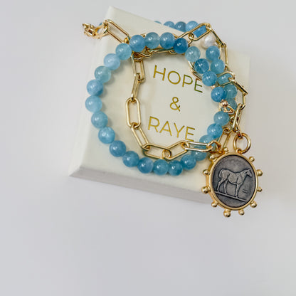 24 inch Aquamarine and gold paperclip chain necklace with bold horse pendant and gold clasp by Hope and Raye.