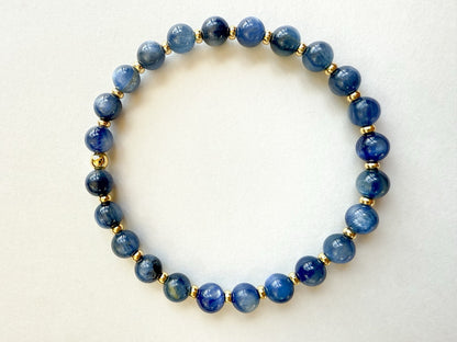 Blue gemstone and gold stretch bracelet handcrafted with smooth round natural blue gemstones and small gold-filled disc beads. Strung on durable stretch cord. HOPE & RAYE.