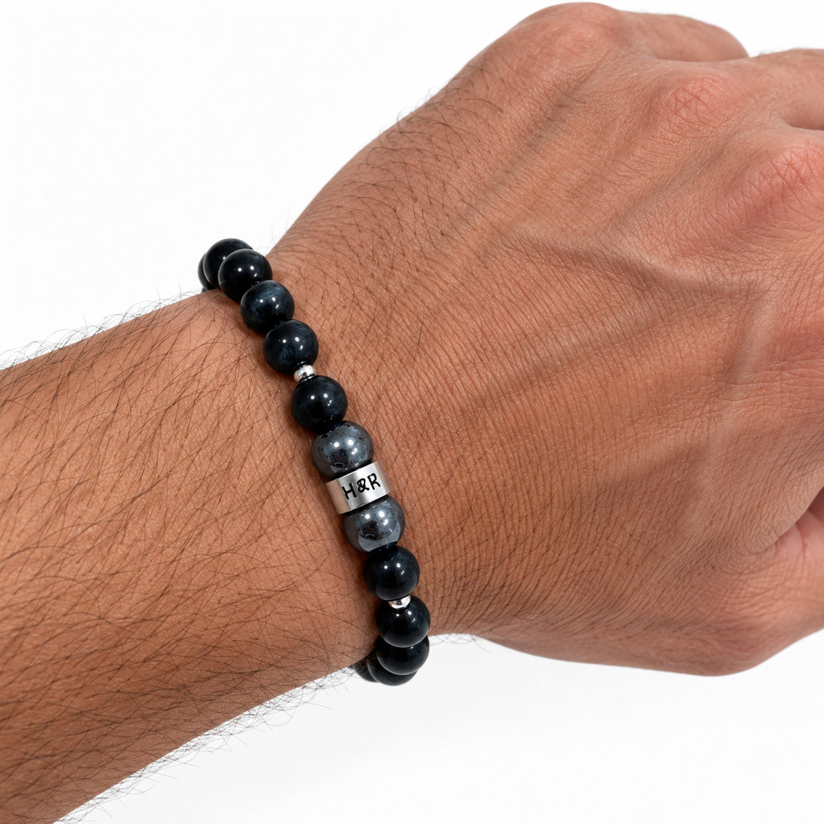 Men’s Falcon’s Eye and hematite stretch bracelet with sterling silver accents on a male wrist.
