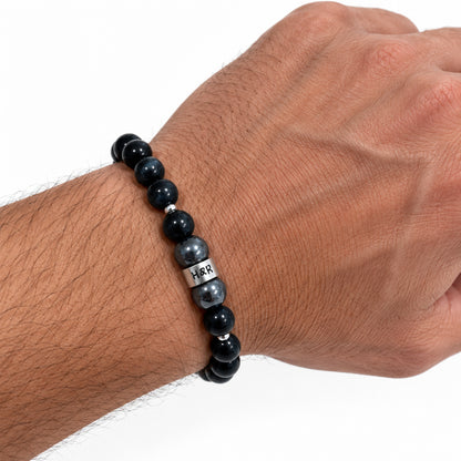 Men’s Falcon’s Eye and hematite stretch bracelet with sterling silver accents on a male wrist.