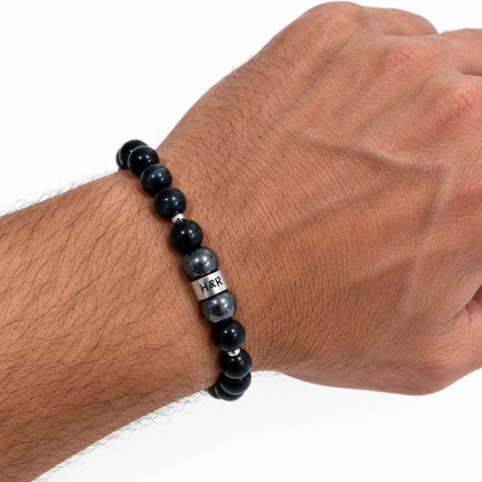 Men’s Falcon’s Eye and hematite stretch bracelet with sterling silver accents on a male wrist.