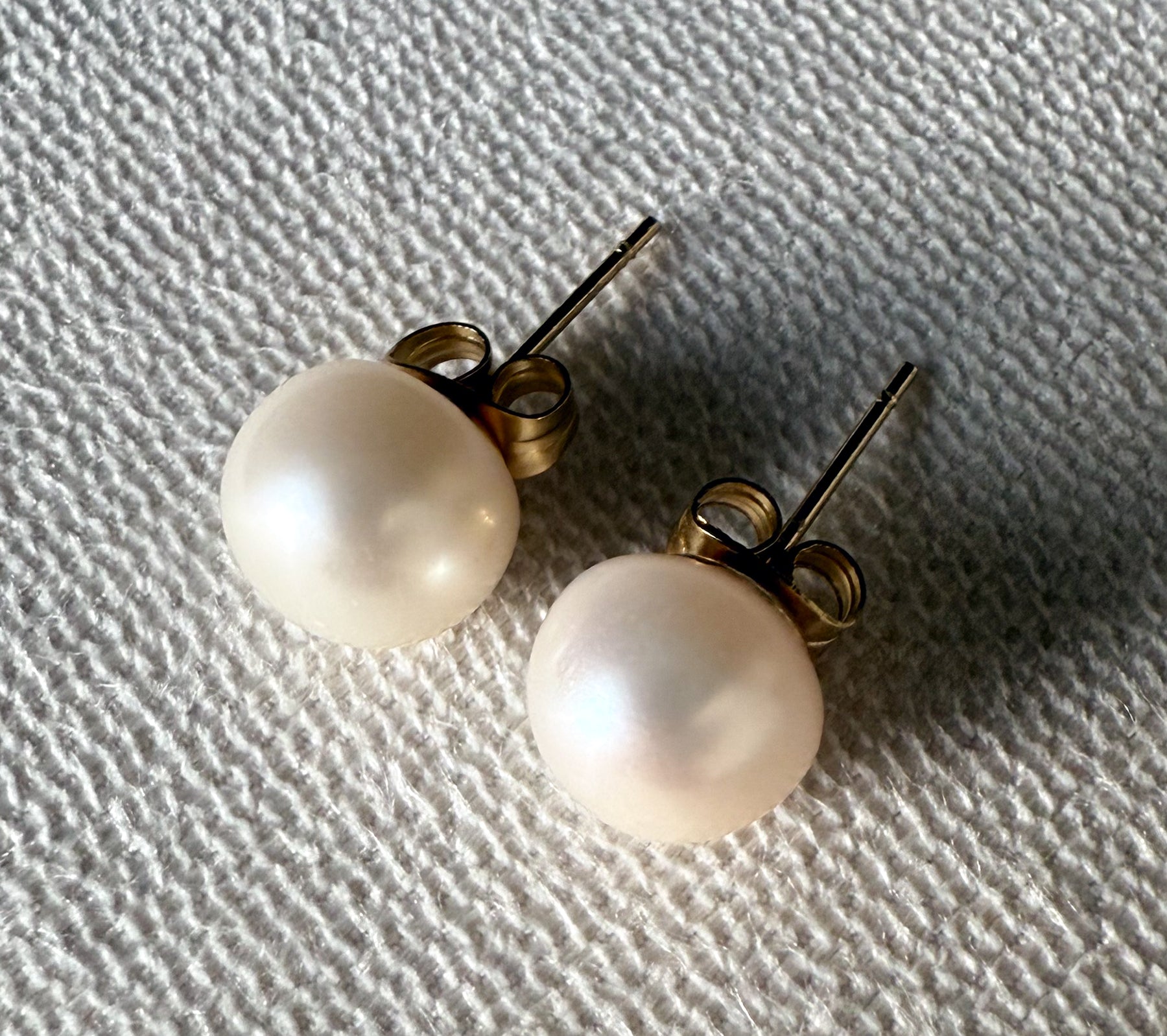 White 8.5 mm genuine freshwater pearl stud earrings with gold filled posts and backs by Hope and Raye.