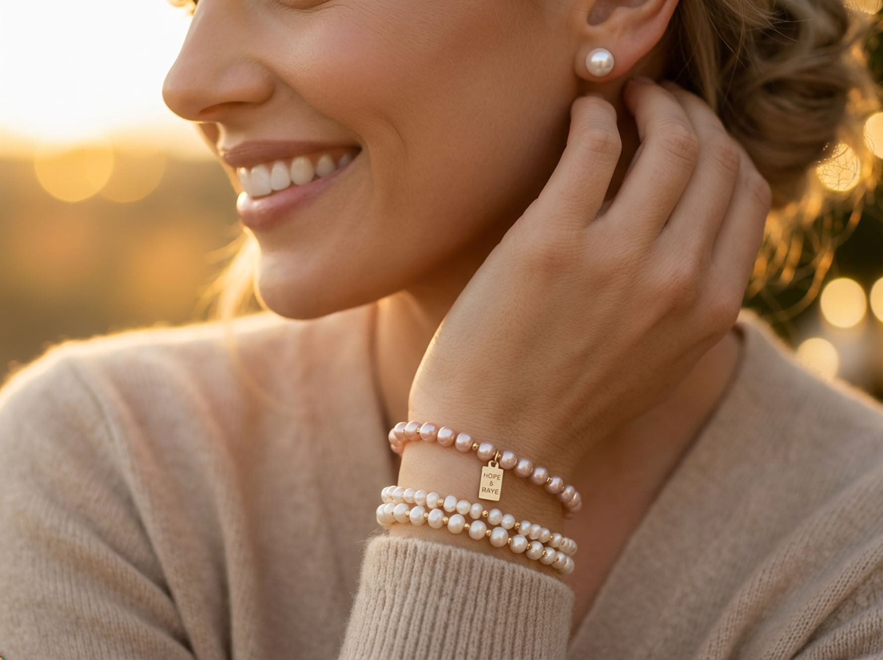 Woman wearing stacked natural pearl bracelets with gold tag jewelry