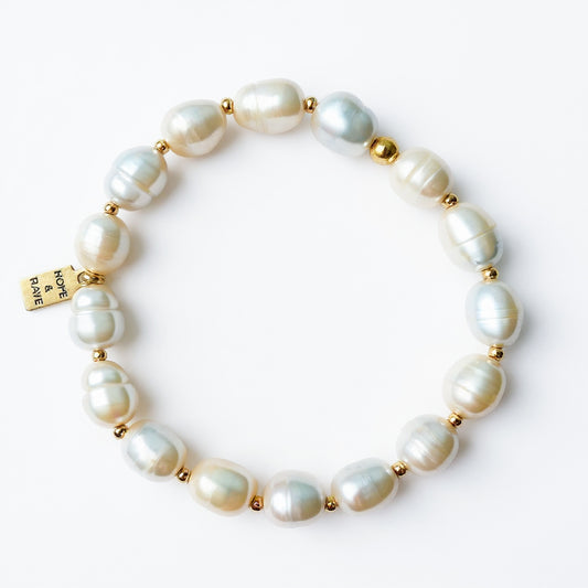 Baroque white pearl stretch layering bracelet with gold discs by Hope and Raye. 
